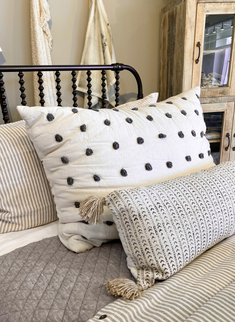 Bed Pillow sham with small pom-poms on a bed