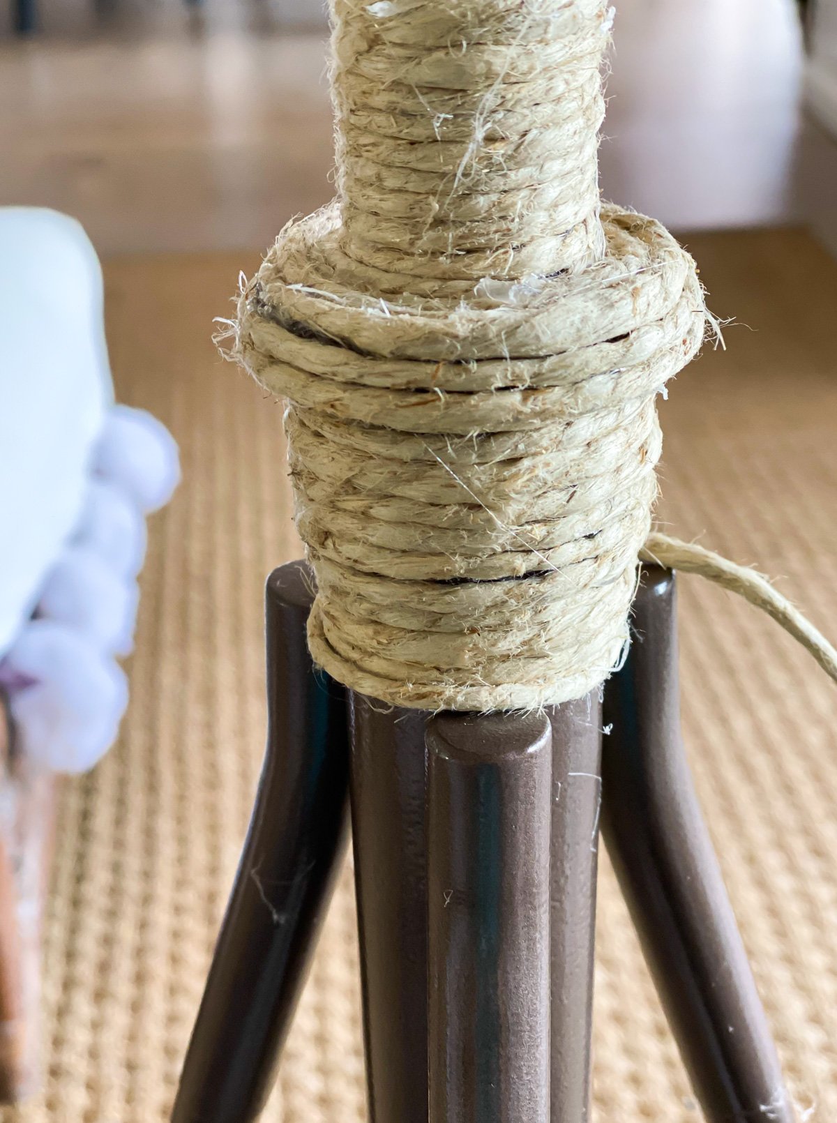 Wrapping twine around a tripod style floor lamp to give it a new look for summer.