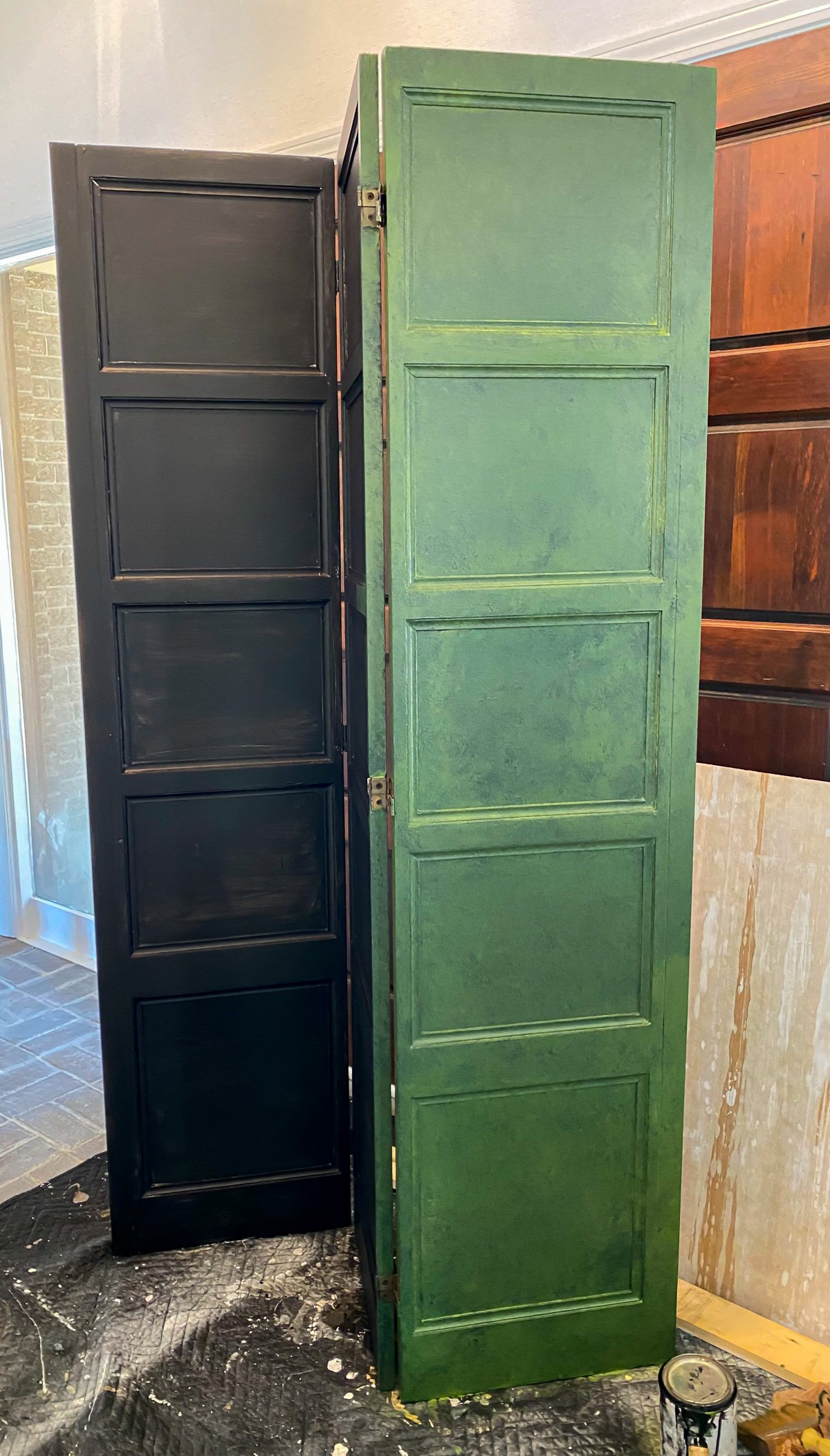 First coat of green paint and glaze mixture added to a decorative wood screen that has a black paint primer on it.