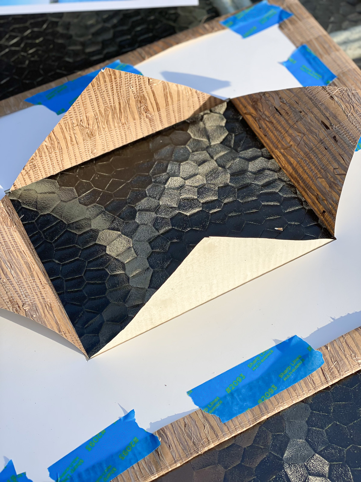 Cutting center of wallpaper and folding it to make a new mat for a picture frame.