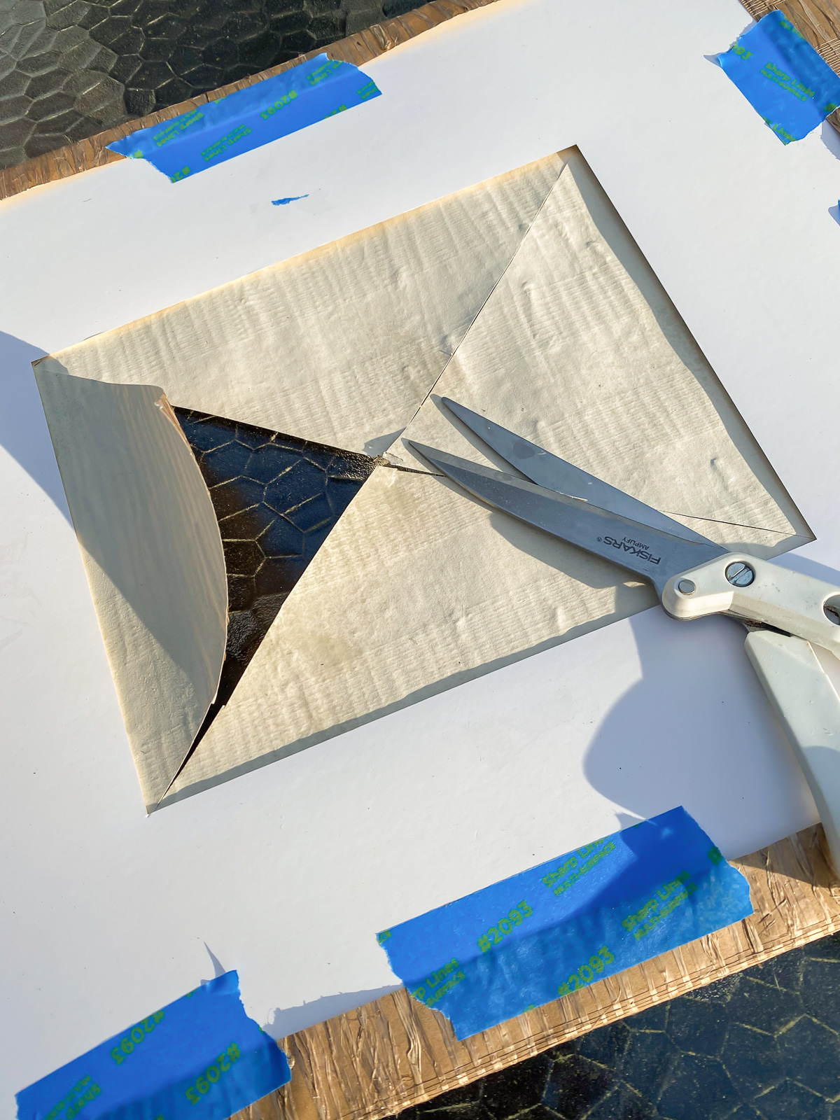 Cutting center of wallpaper to make a new mat for a picture frame.