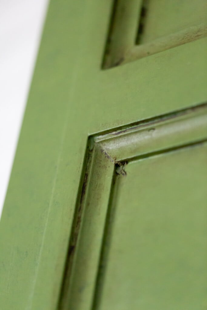 close up of a decorative paneled painted with green paint and glaze. Sealed with Annie Sloan dark wax.
