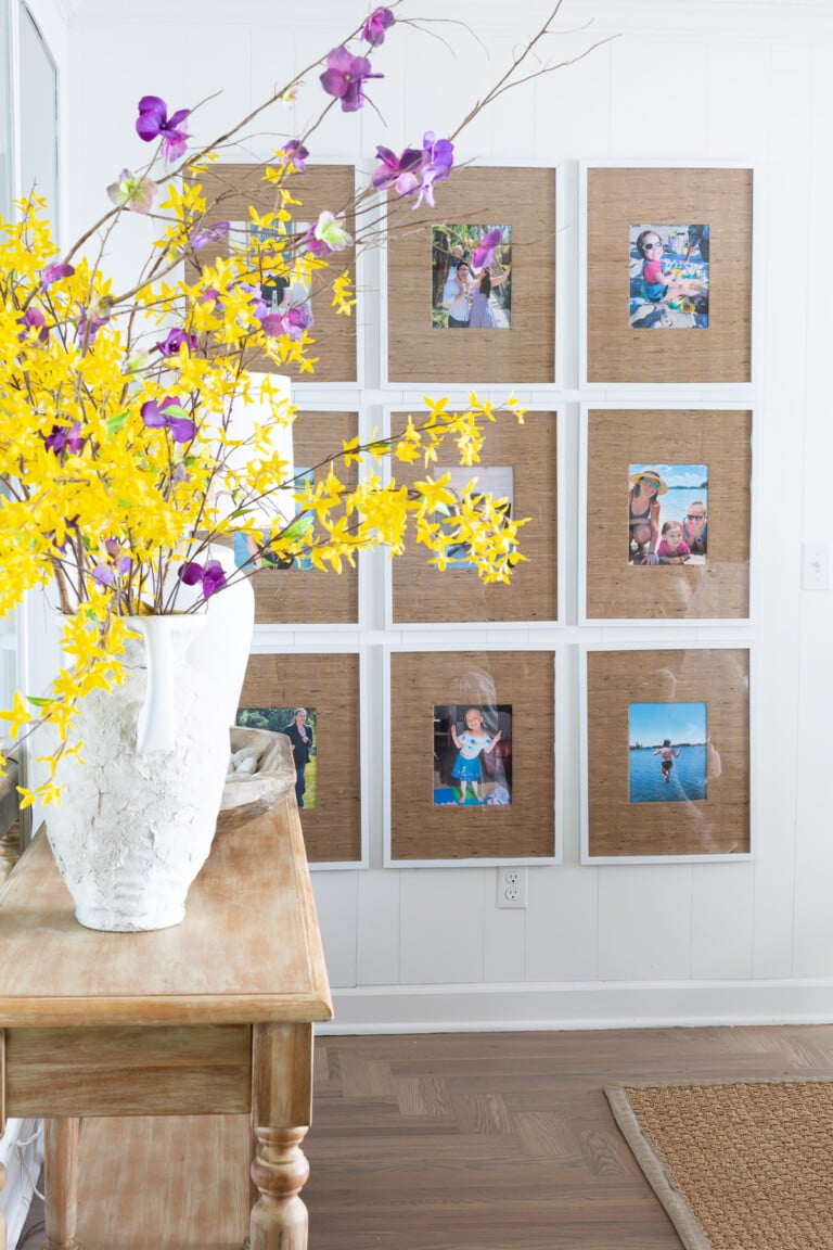 9 grid gallery wall in living room with grasscloth wallpaper remnant photo frame mats.