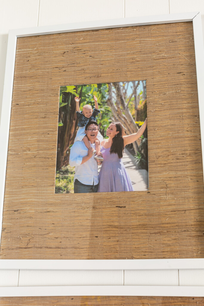 color photo of family in grasscloth wallpaper matted picture frame.