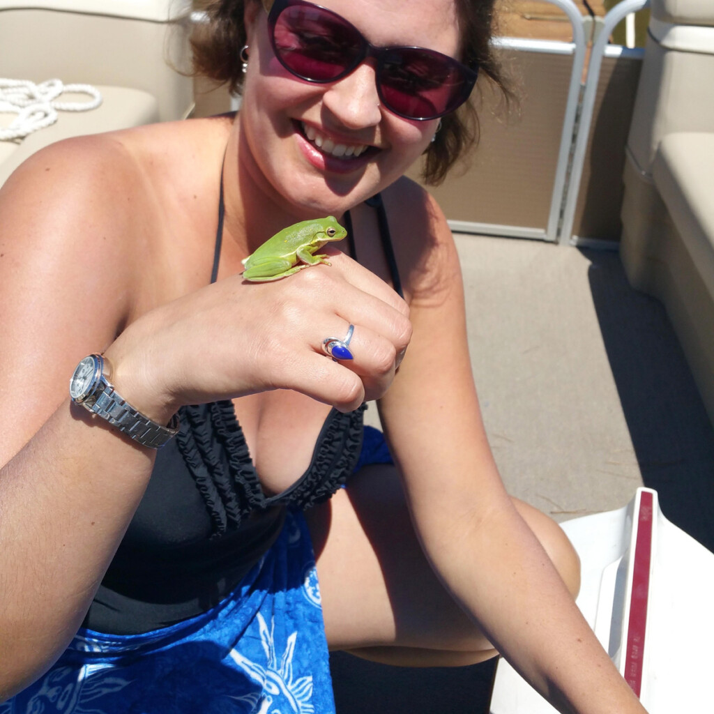 girl holding a green frog found outside
