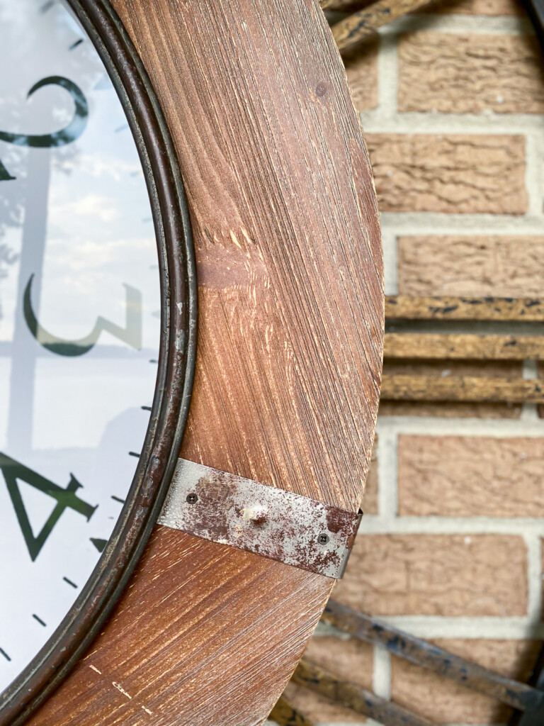 close up of wood frame on large outdoor wall clock.