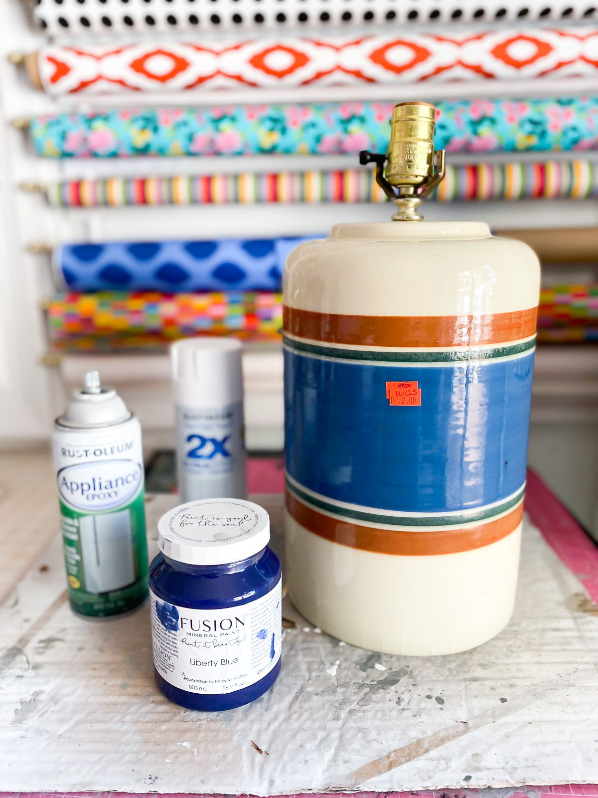 Thrift store table lamp and paints on table before getting painted.