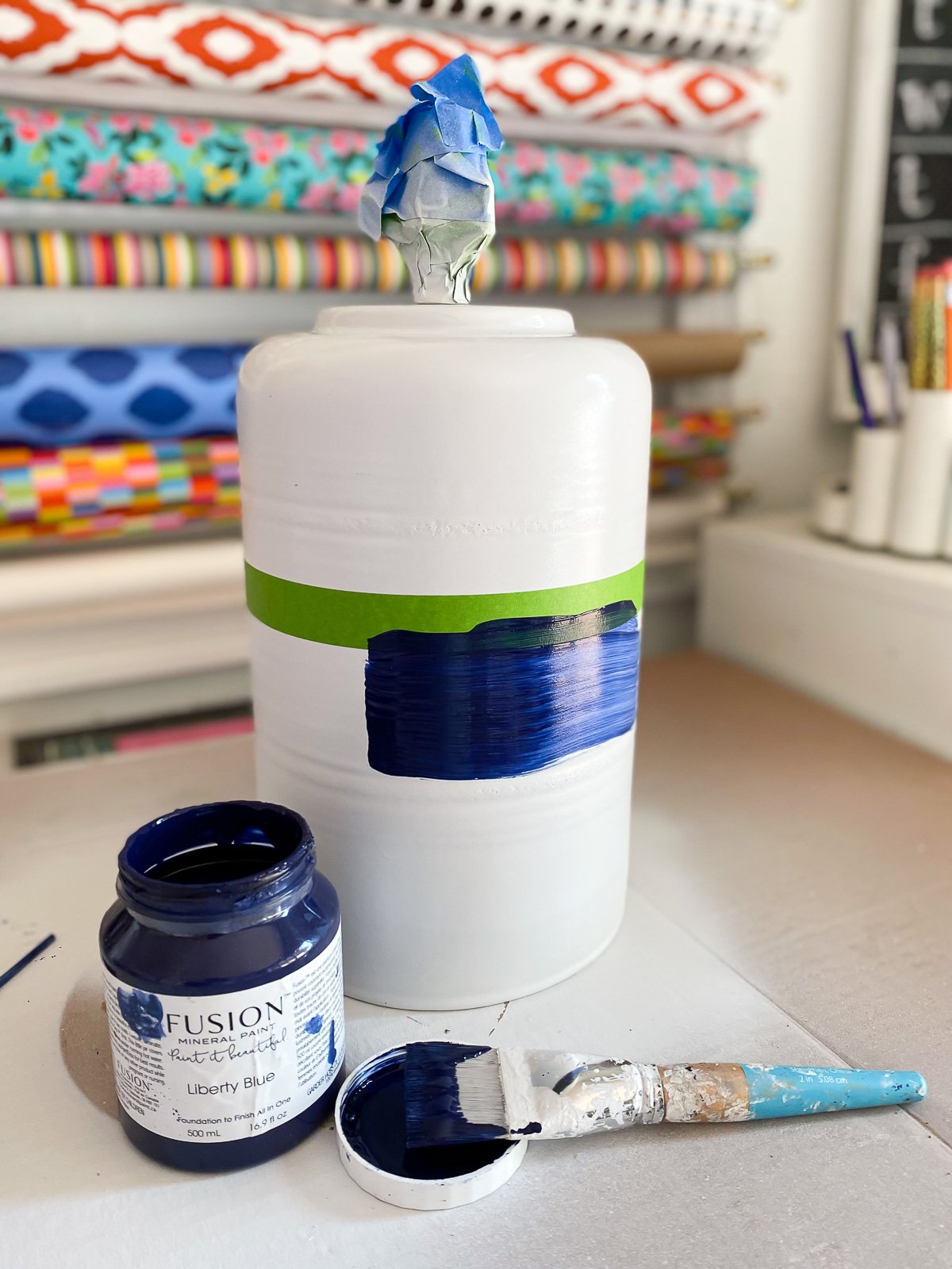 Blue paint being applied to white spray painted lamp base.