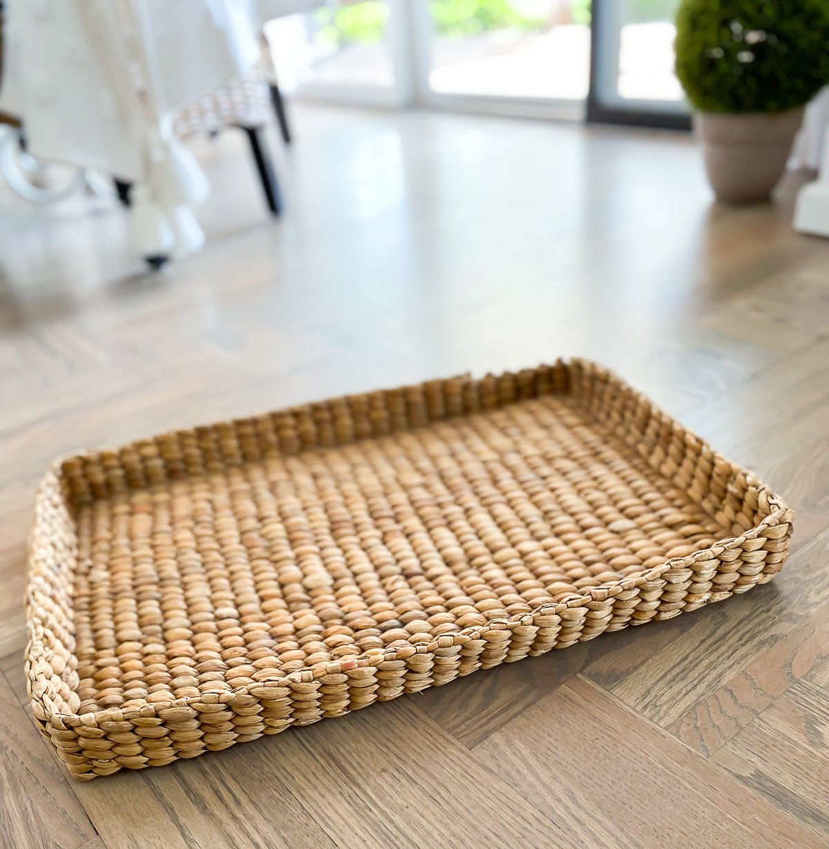 large woven tray from Pottery Barn on floor