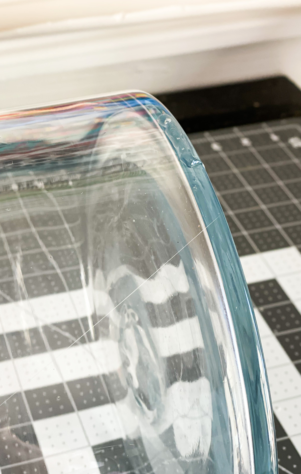 glass vase on its side with a a line of hot glue on the bottom edge