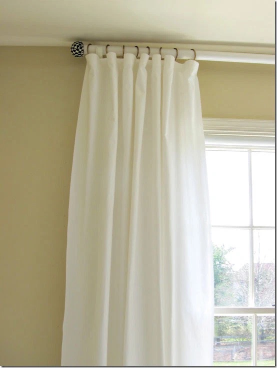 white drapes on rod with tennis ball finials
