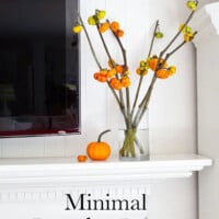 Minimal pumpkin decor on a white mantle next to a wall mounted tv