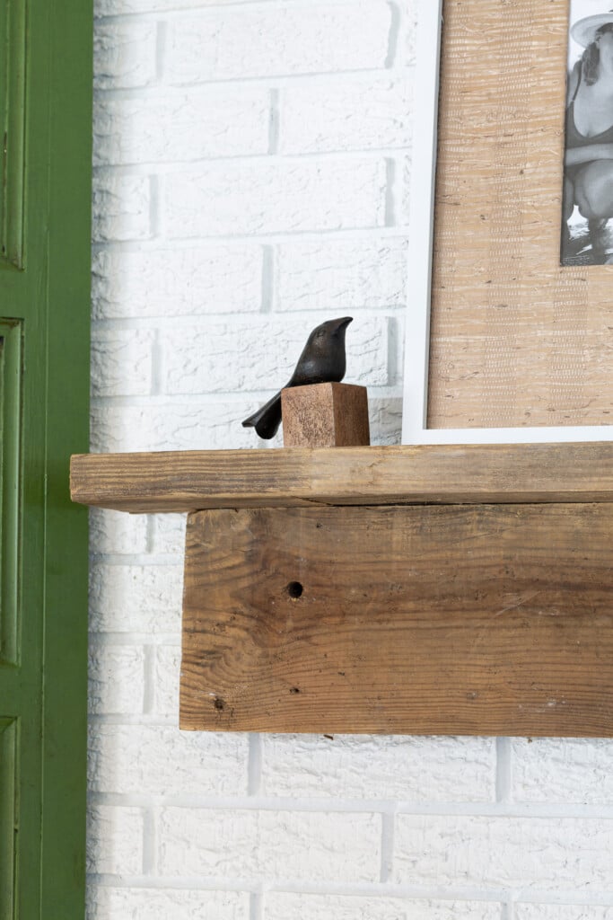 small bird figurine on rustic DIY fireplace mantel