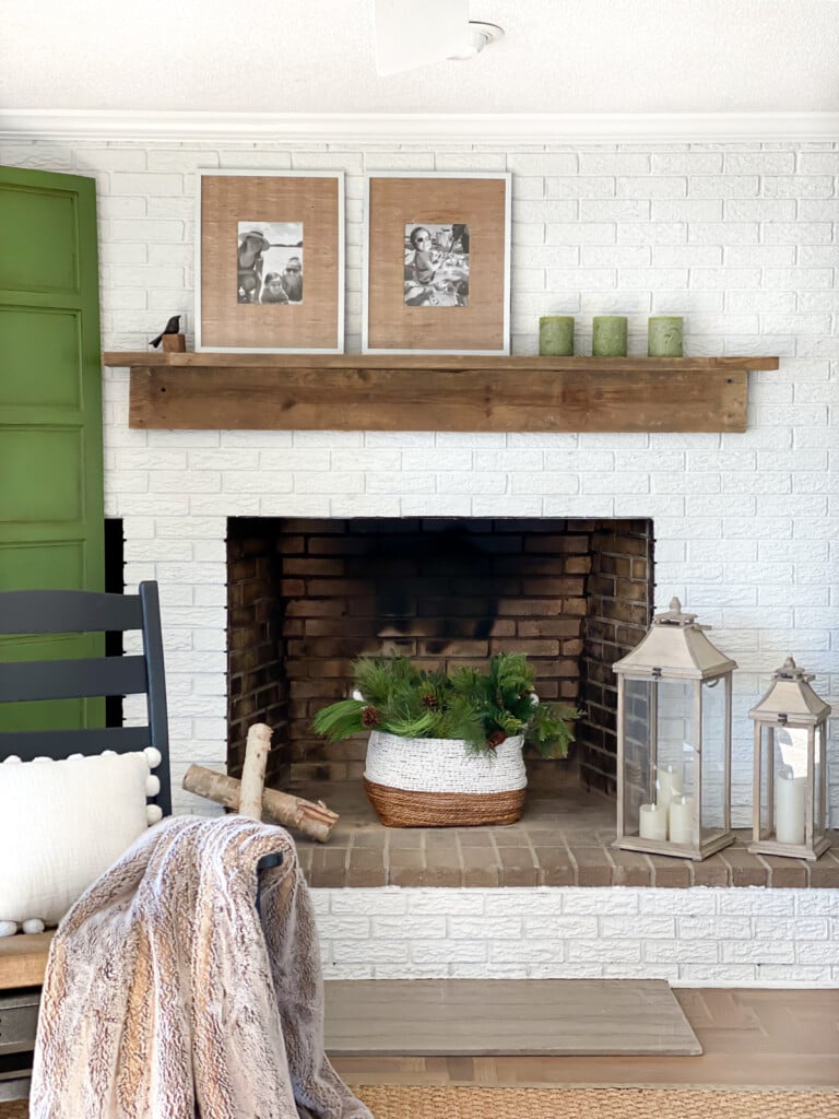 Living room with white brick fireplace wall and reclaimed wood DIY mantel