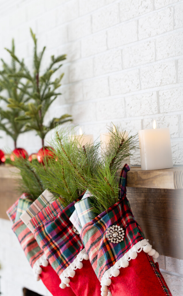 3 red plaid stockings hanging on a wood mantel