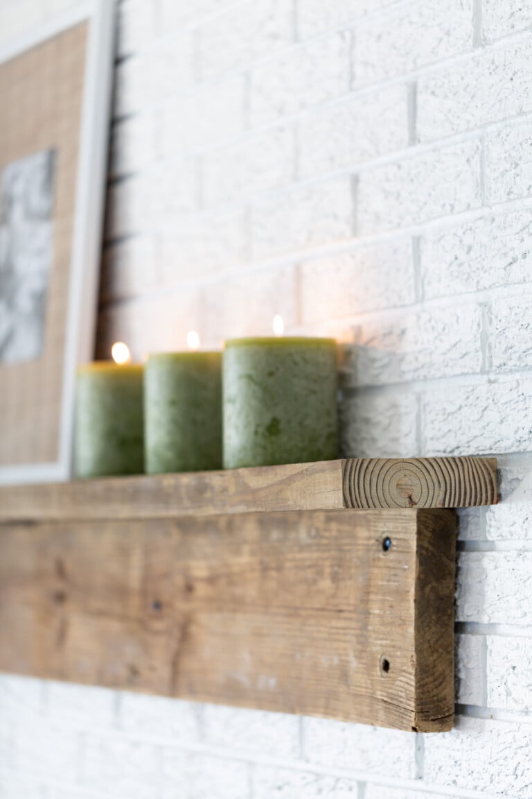 3 green pillar candles in DIY rustic wood mantel