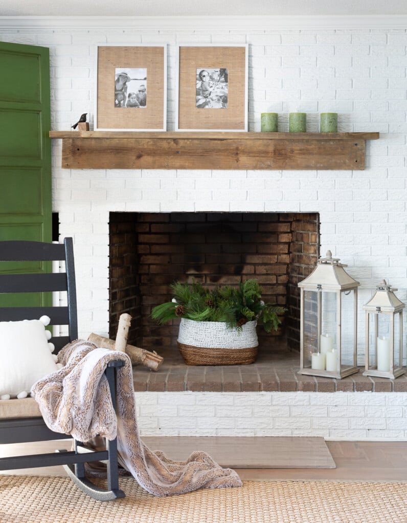 Living room with white brick fireplace wall and reclaimed wood DIY mantel