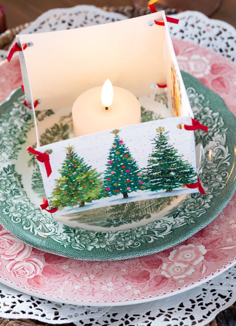 Candle placed inside a box made of old Christmas cards