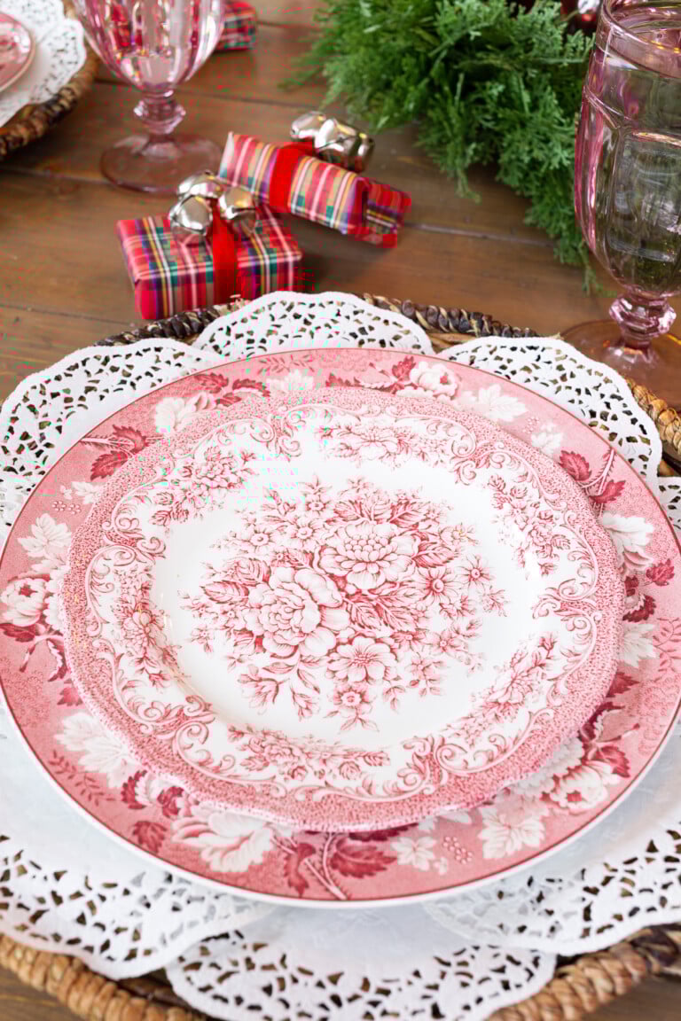 Vintage red and white dinner plates on a round placemat made with paper doilies.