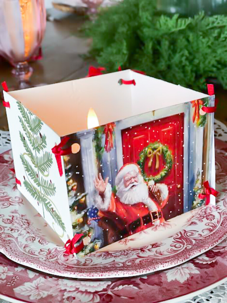 Repurpose Christmas cards into a decorative accent for a votive candle on a dinner table setting.