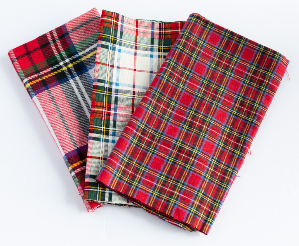 3 red plaid fabrics made into dinner table napkins.