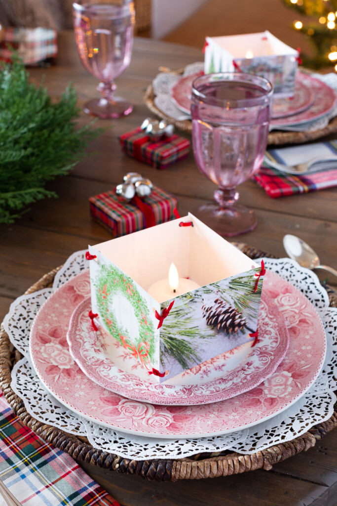 Setting the table for Christmas with red and white plates, candles and plaid accents
