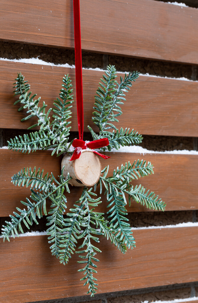 Christmas wreath alternative using a tree trunk slice and pine branches.