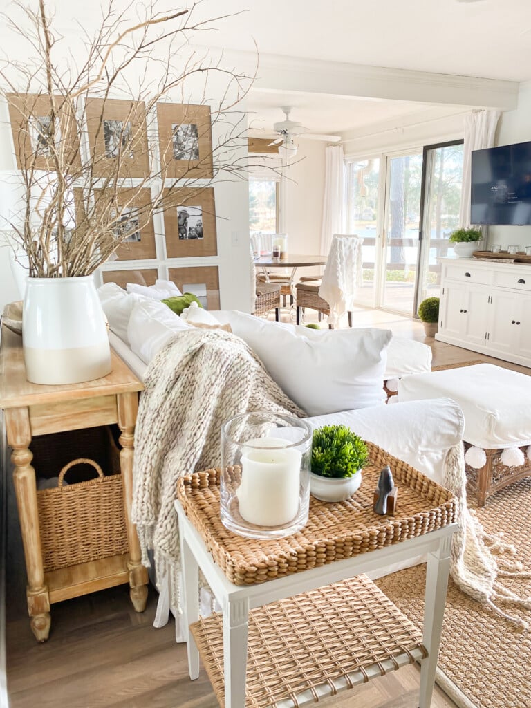 Small neutrally decorated living room that has no coffee table, instead two large ottomans.