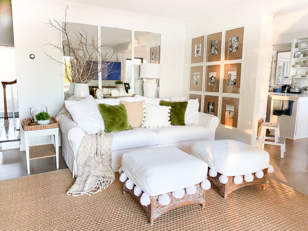 Small neutrally decorated living room that has no coffee table, instead two large ottomans.