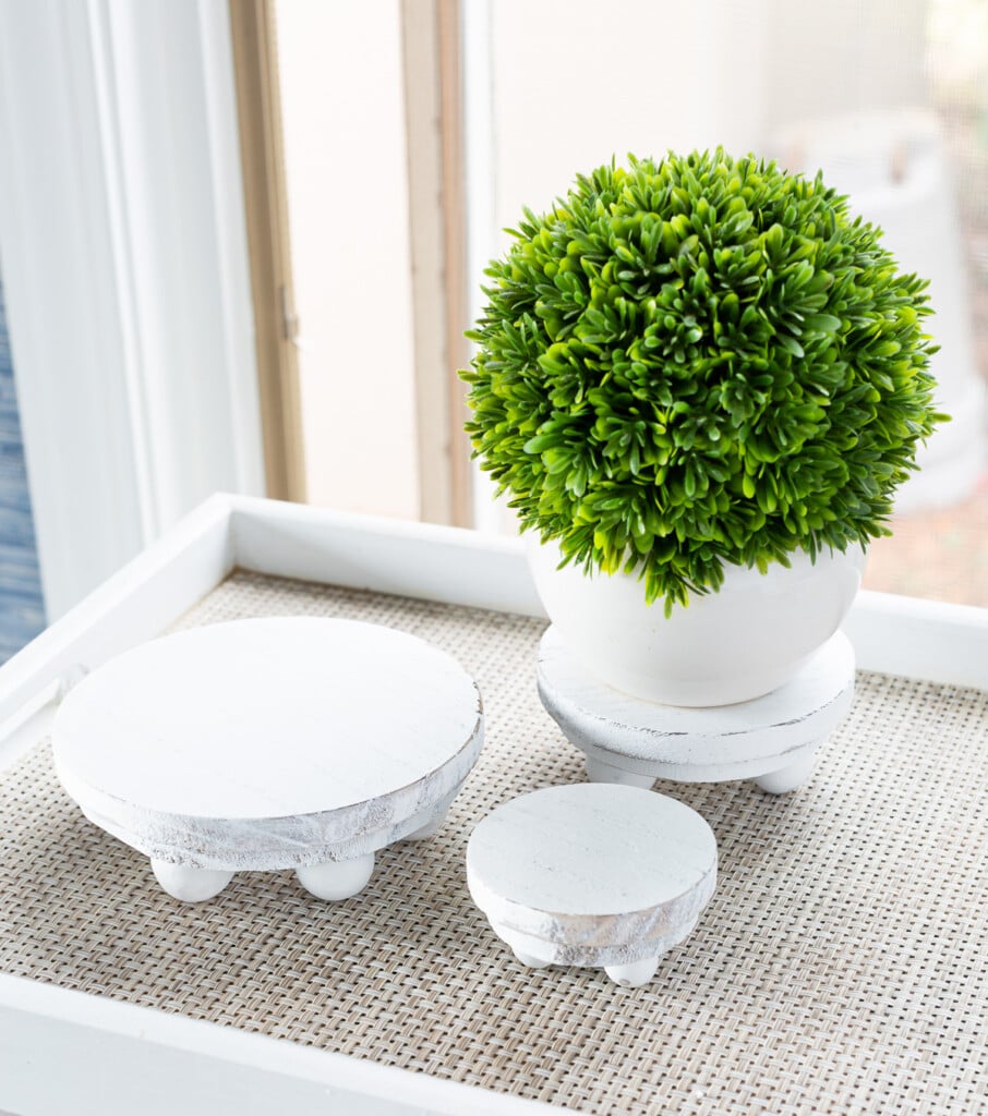 3 small risers in white that can be used to add height to table lamps and more.