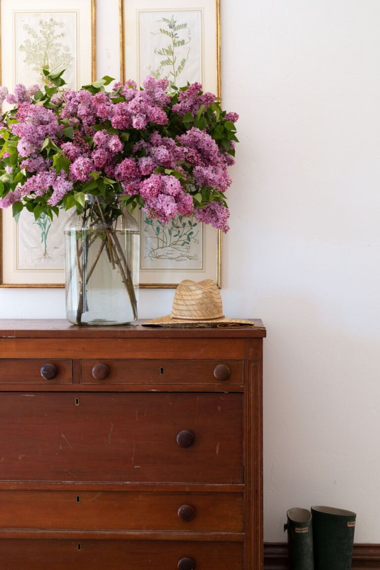 Farmhouse dresser with a large glass vase of lilacs