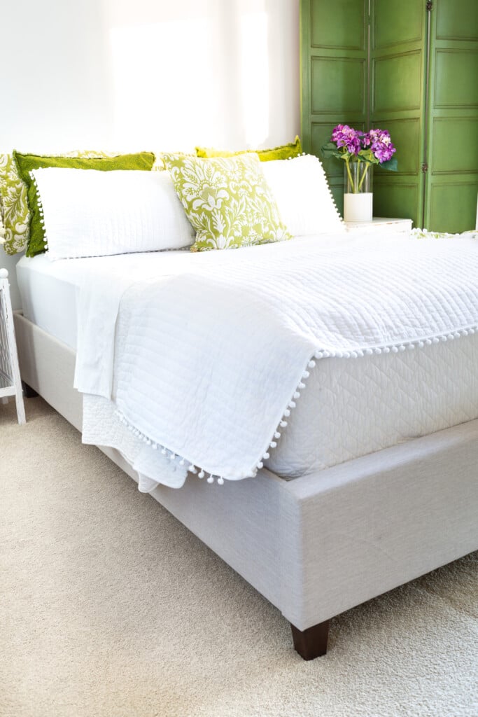 Christeli mattress and Eastman platform bed in a white and green decorated guest room.