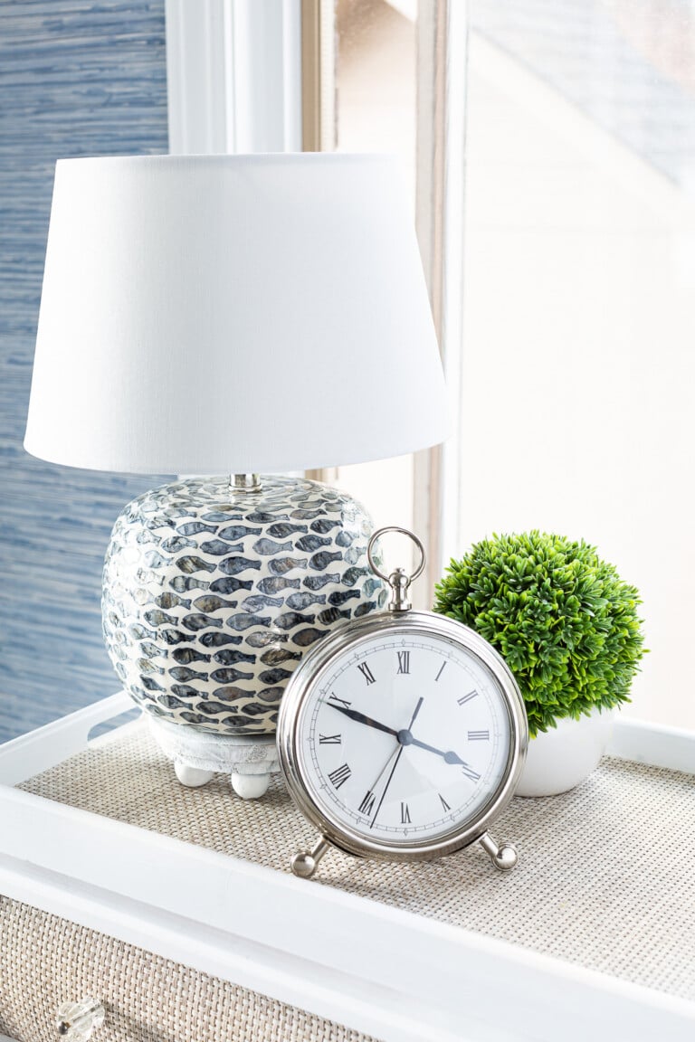 blue and white table lamp with a small riser under it.