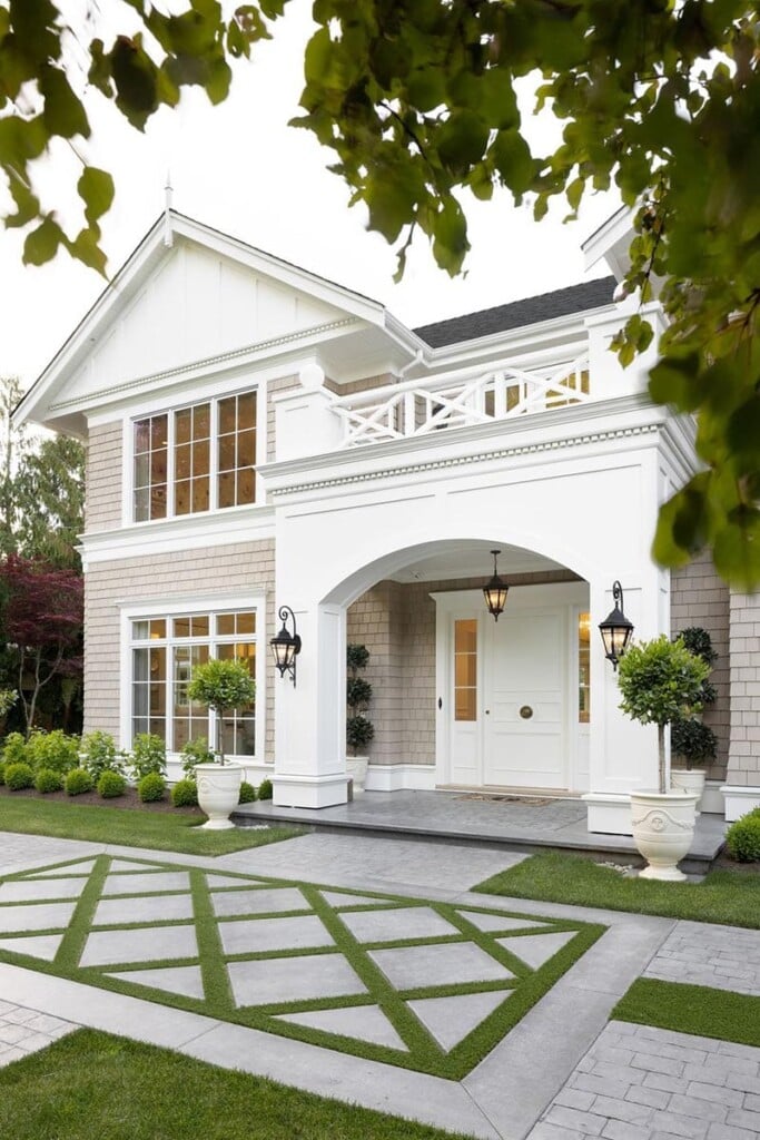 beautiful white and beige exterior on a home with a grass and concrete design in the front