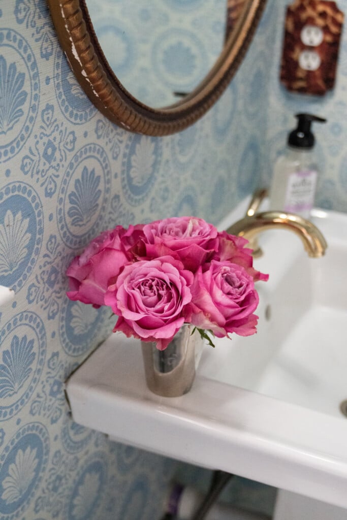 a pretty blue and white wallpapered bathroom