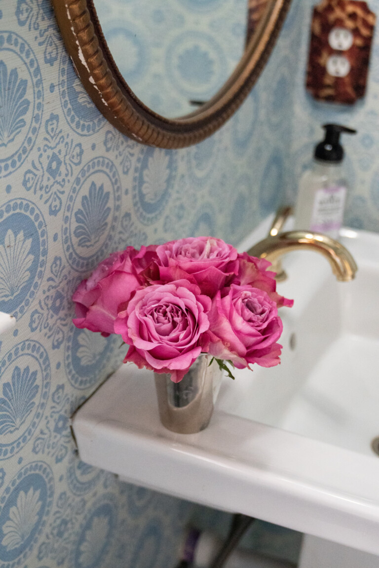 a pretty blue and white wallpapered bathroom