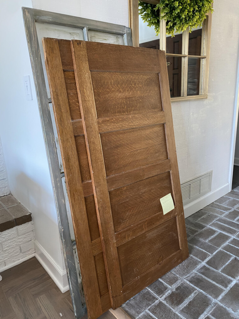 2 wood panels from an old file cabinet leaning against a wall.