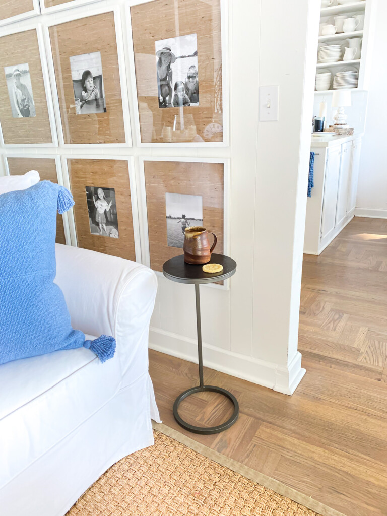 A corner in a living room with a sofa and small accent table to hold a drink.