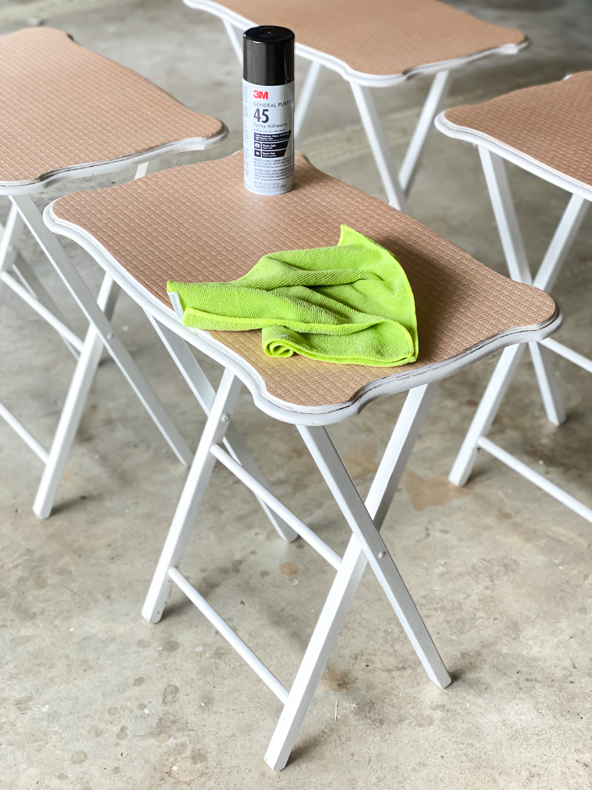 decoupage furniture - a set of tray tables being done with spray glue for a quick and easy application of decorative paper on the surface.