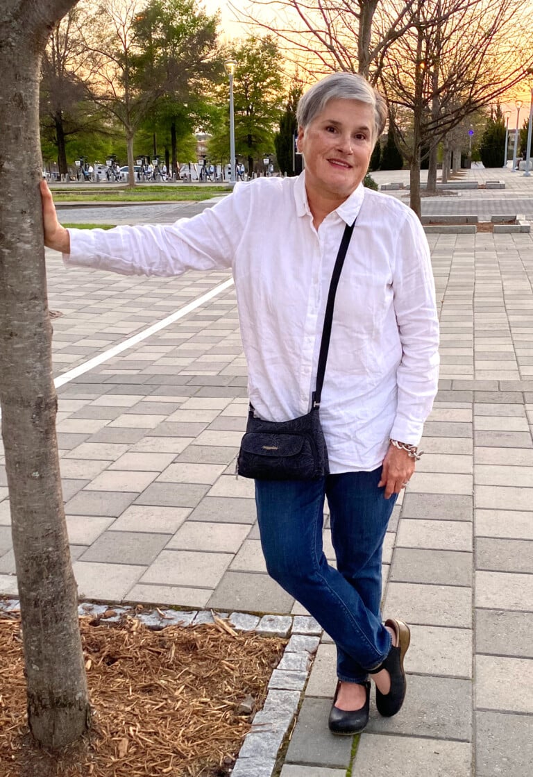 blogger Diane standing outside with a crossbody bag strapped over body