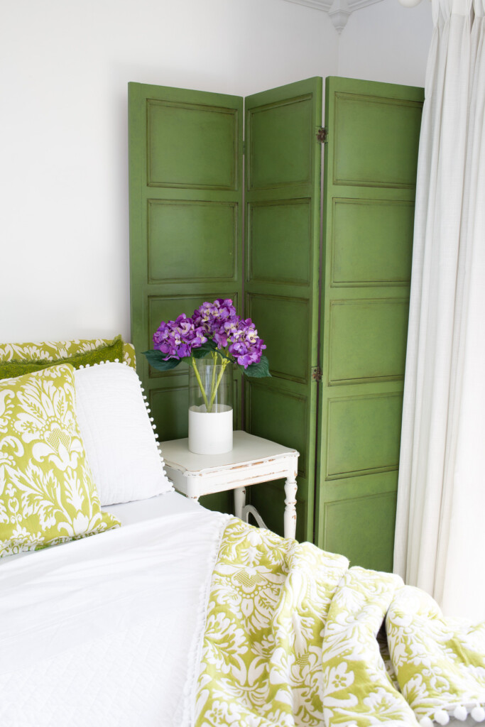 Glazed green painted decorative screen in green and white guest room.