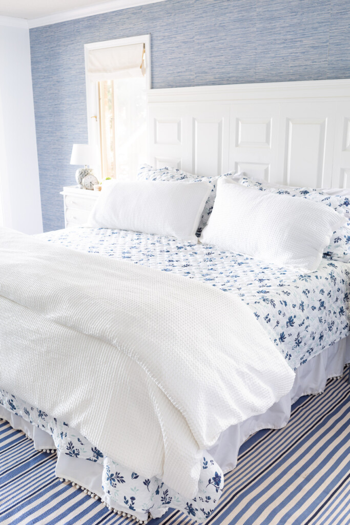 Cozy lightweight summer floral bedding on a bed in a blue and white decorating color scheme.