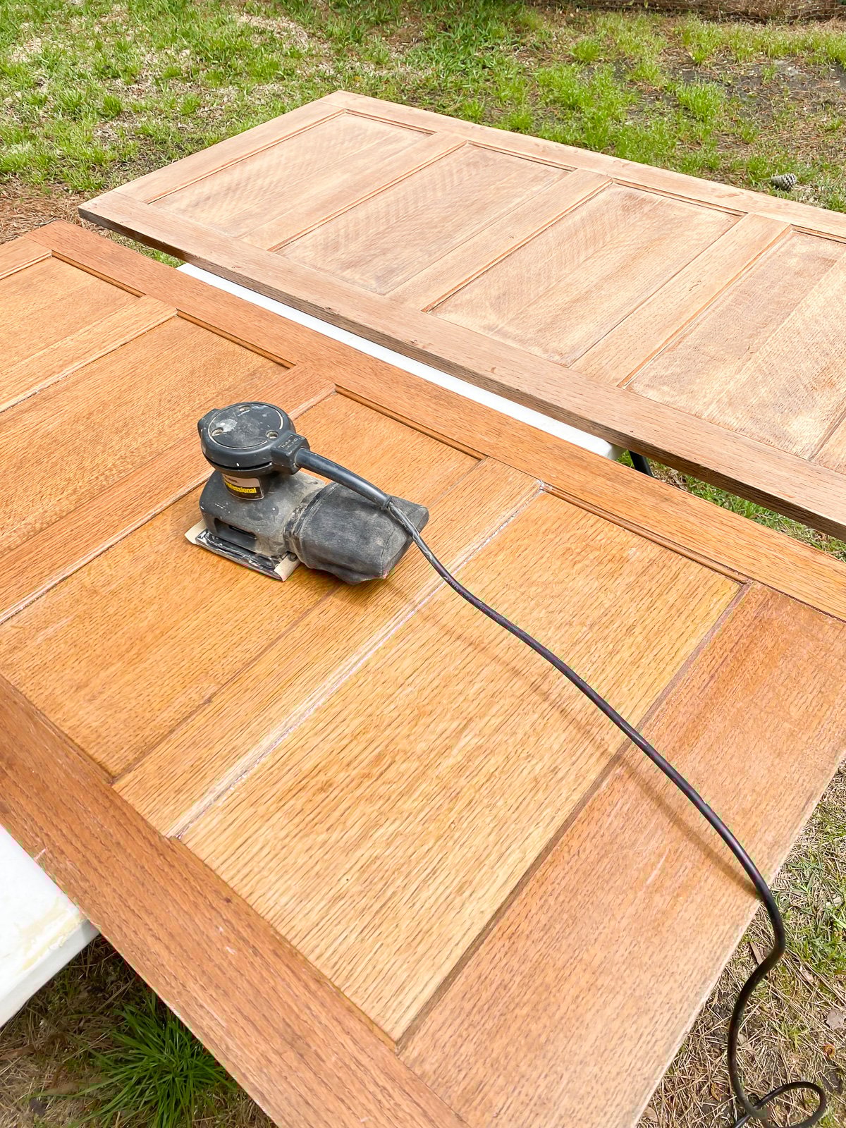 Sanding orange hue stain from two wood panels.