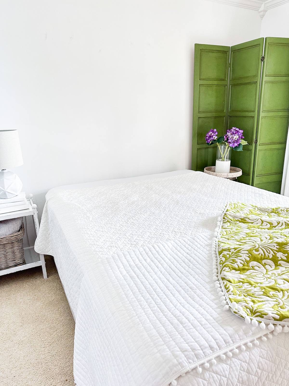 Queen size upholstered bed frame without a headboard in a bedroom.