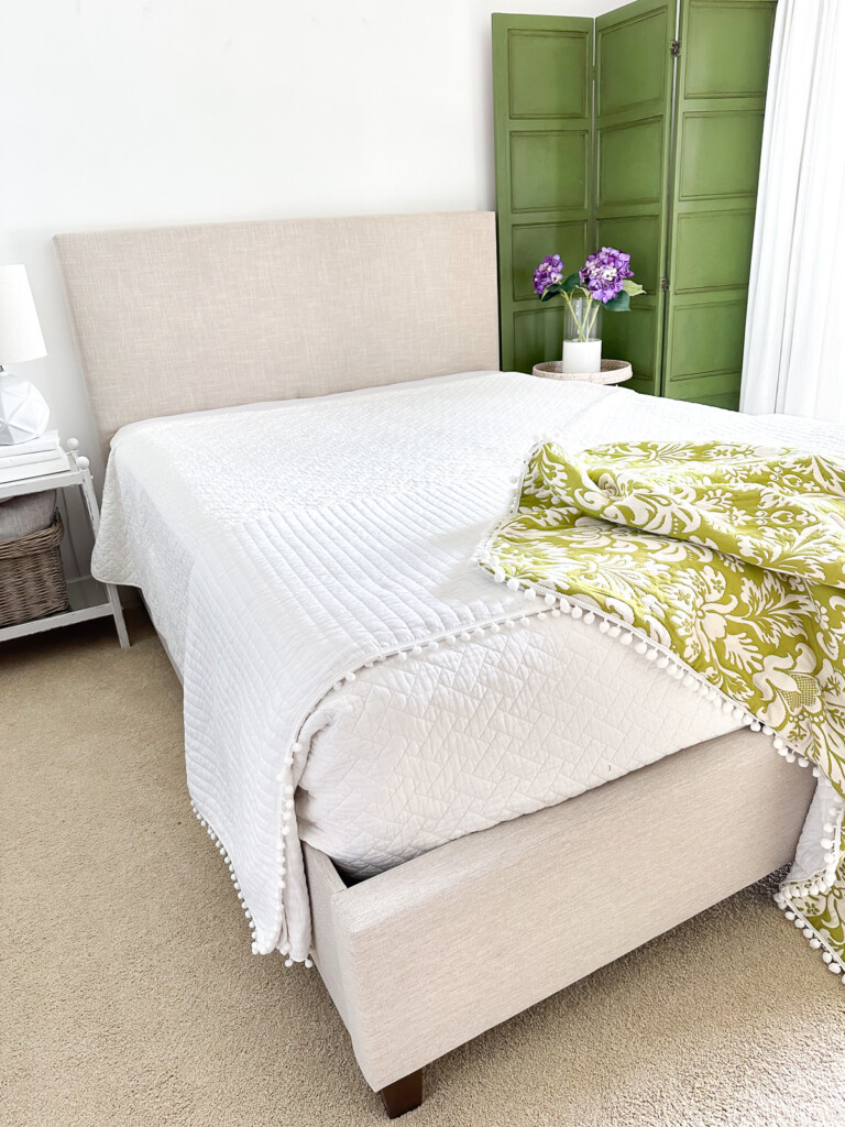 Completed DIY upholstered headboard attached to an existing upholstered bed frame.
