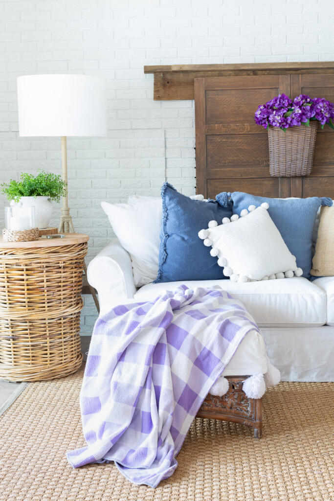faux brick paneling is used to cover up a firewood storage area for the summer on a brick accent wall in a living room.