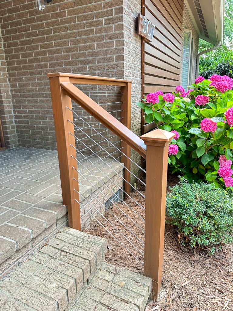 brick front porch railing being stained before cable railing sections added.