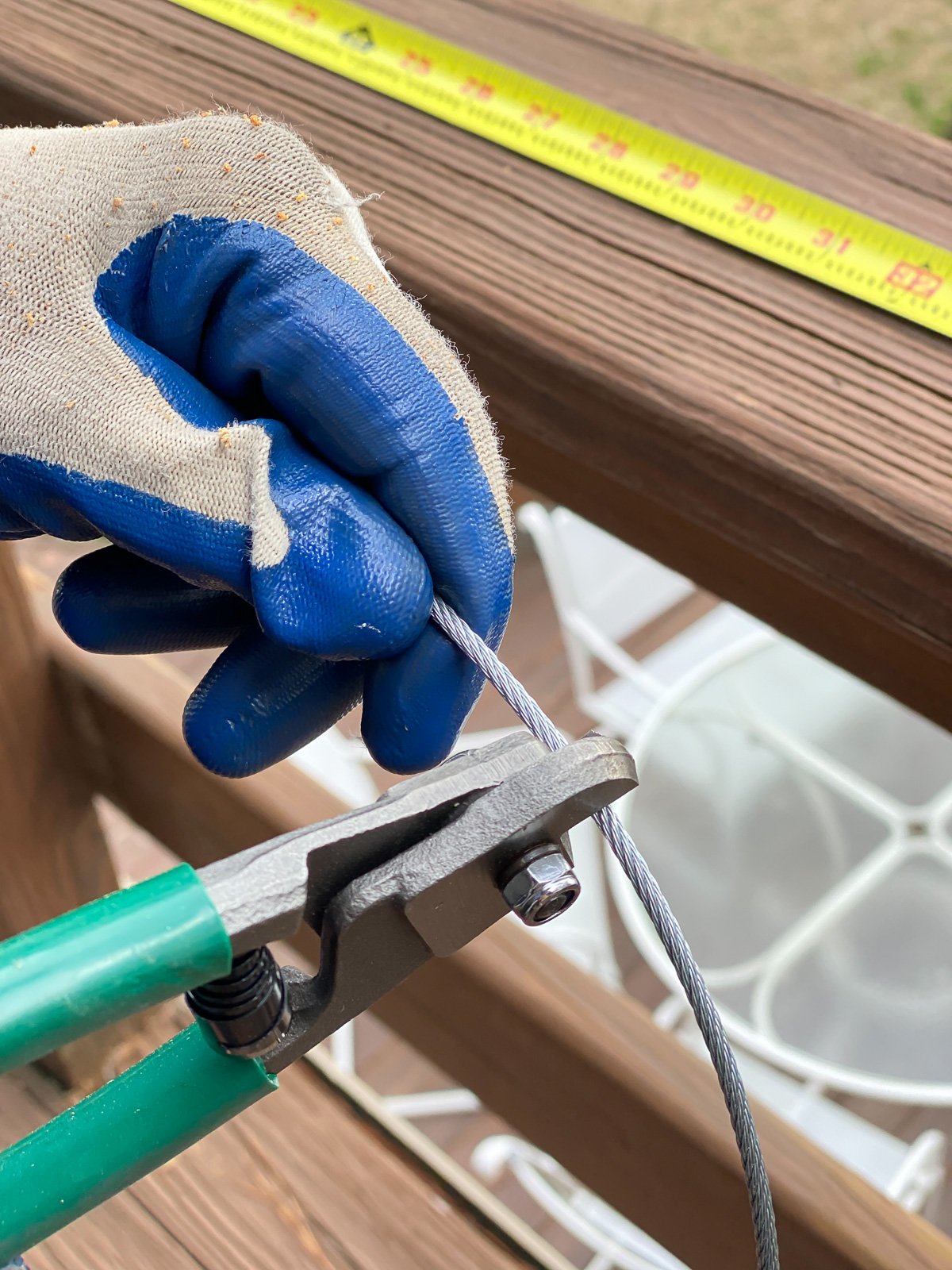 cutting the cable railing wire with wire cutters.