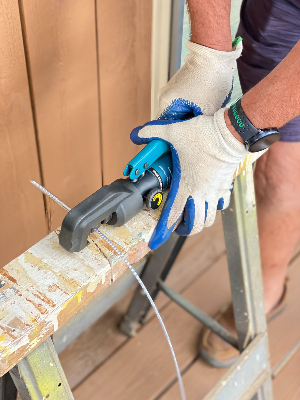 Using the cable railing crimper on a saw horse to help with leverage until you get the hang of using the crimper.
