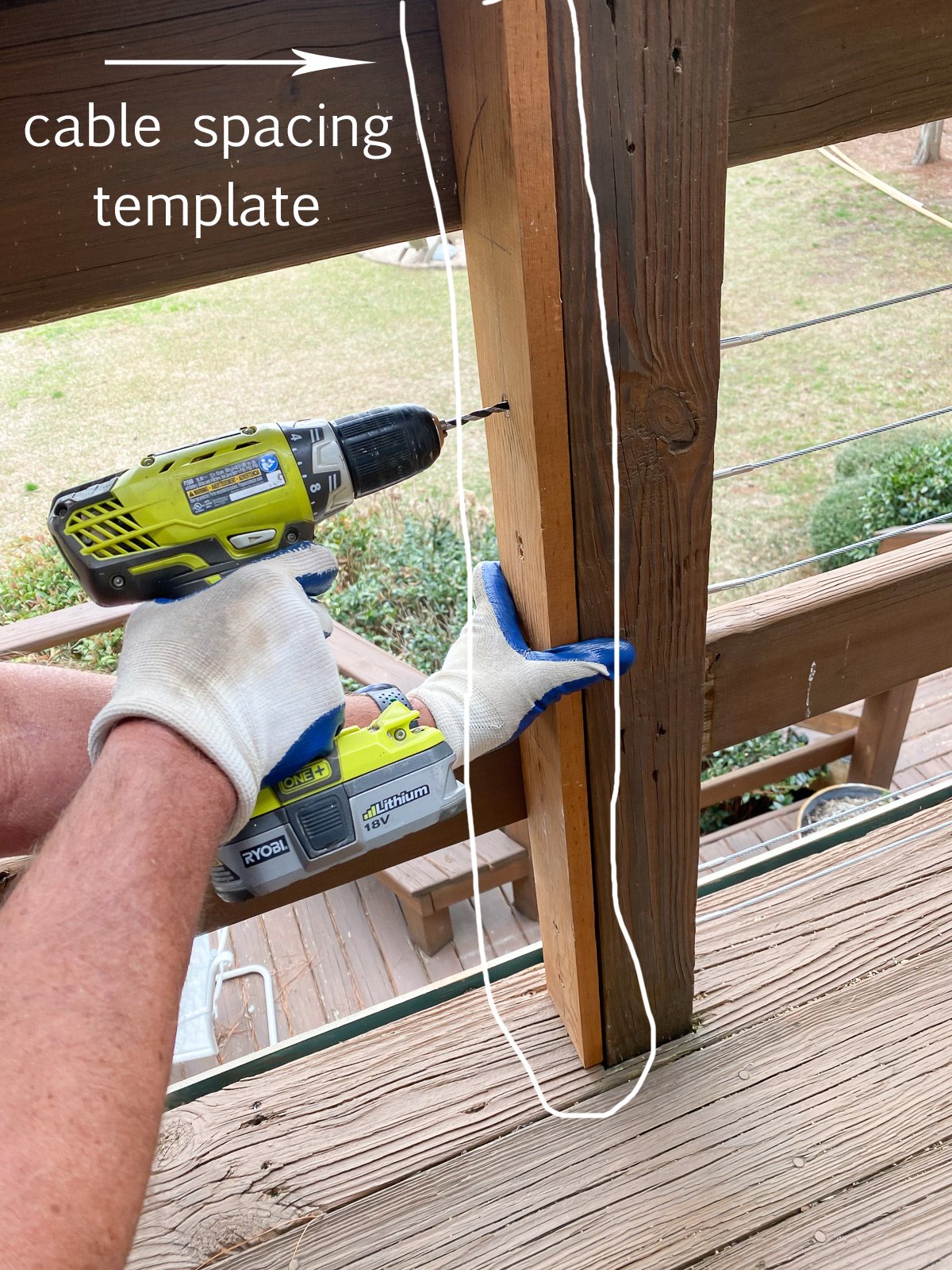 cable railing spacing template being held in place to drill holes at the right spacing. You can also use a clamp to hold it.